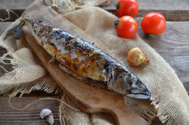 Grilled mackerel on a grill on coals in foil baked