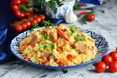 Pork pilaf in a saucepan on the stove crumbly