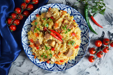 Pork pilaf in a saucepan on the stove crumbly