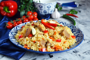 Pork pilaf in a saucepan on the stove crumbly