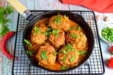 Minced hedgehogs with rice in a frying pan with gravy