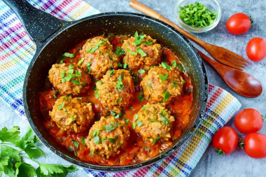 Minced hedgehogs with rice in a frying pan with gravy