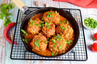 Minced hedgehogs with rice in a frying pan with gravy