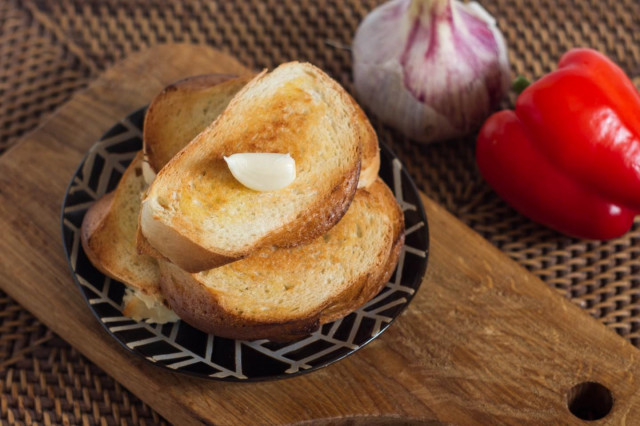 Croutons from a loaf with garlic in a frying pan