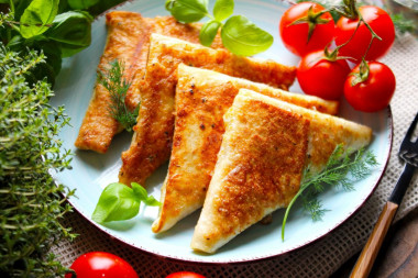 Triangles of pita bread with ham and cheese in a frying pan