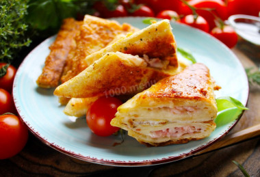 Triangles of pita bread with ham and cheese in a frying pan