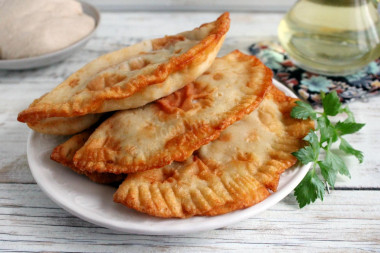 Chebureks in a pan with meat