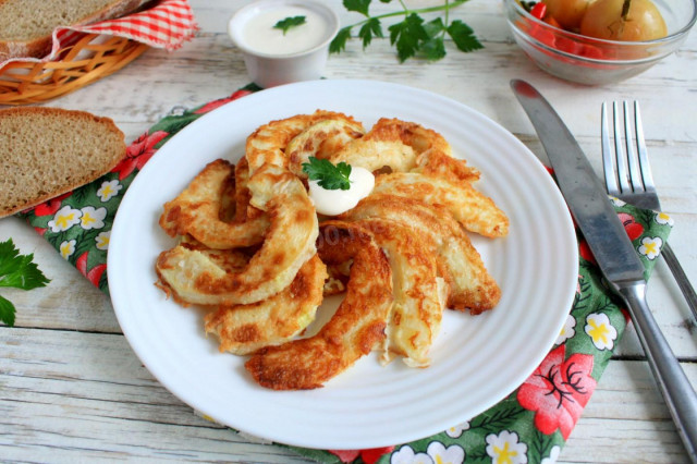 Zucchini in batter in a pan with garlic