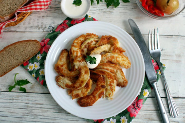 Zucchini in batter in a pan with garlic