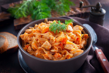 Stewed chicken breast with cabbage in a frying pan