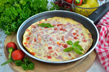 Fluffy omelet with milk and sausage in a frying pan