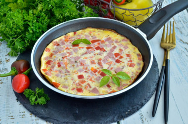 Fluffy omelet with milk and sausage in a frying pan