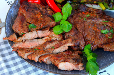 Beef steak on a grill on a grill on coals