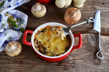 Mushrooms in sour cream with cheese and onions baked in the oven