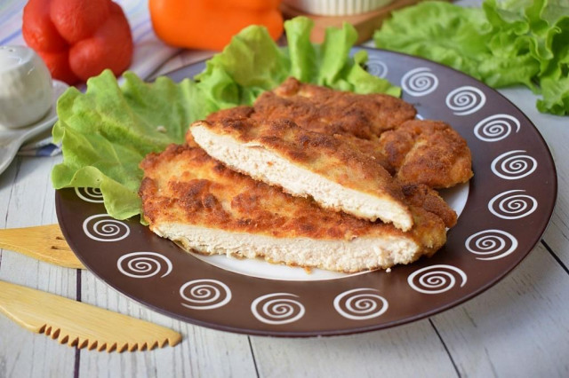 Breaded chicken schnitzel from breast in a frying pan