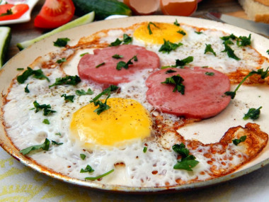 Fried eggs with sausage in a frying pan