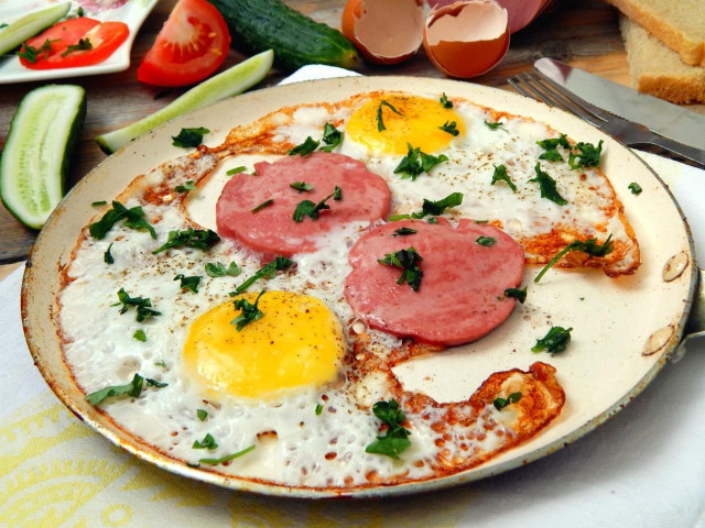 Fried eggs with sausage in a frying pan