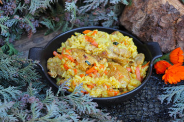 Pork pilaf in a cauldron over a campfire