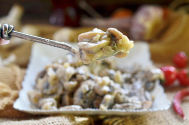 Mushrooms in sour cream with garlic in a pan