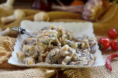 Mushrooms in sour cream with garlic in a pan