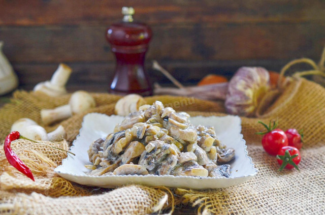 Mushrooms in sour cream with garlic in a pan